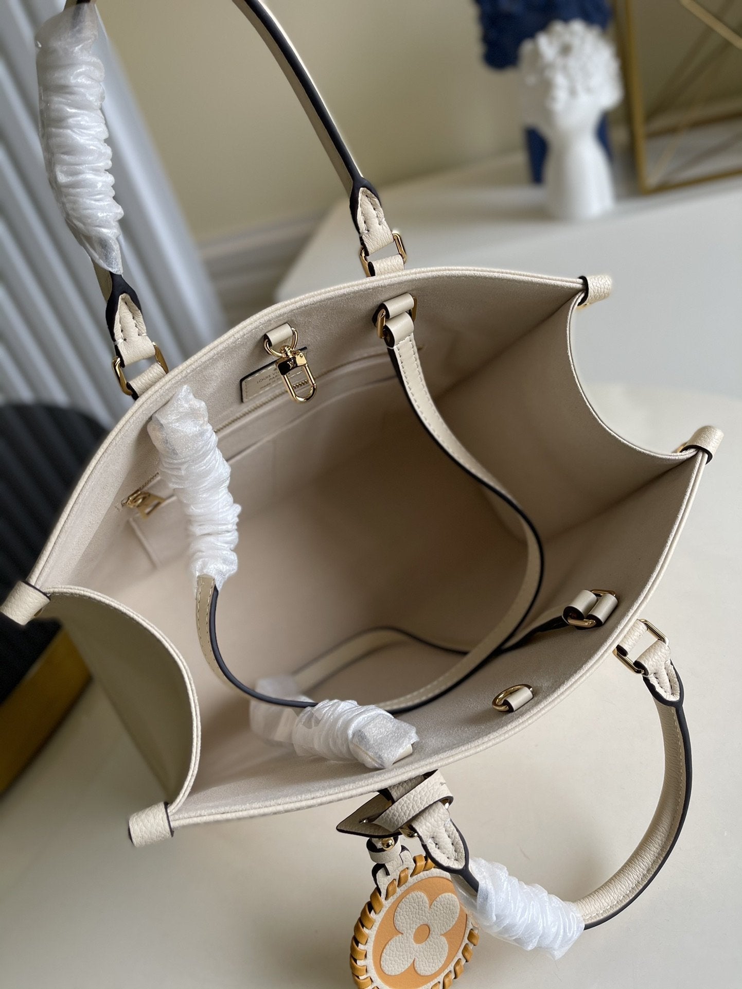 LV ONTHEGO MM 35 CRÈME AVEC GARNITURES EN CUIR DE VACHE 