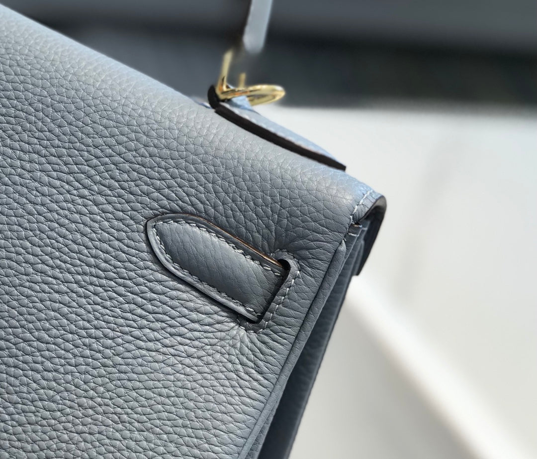 Sac HM Kelly 32 cm en cuir Togo bleu bébé et accessoires dorés