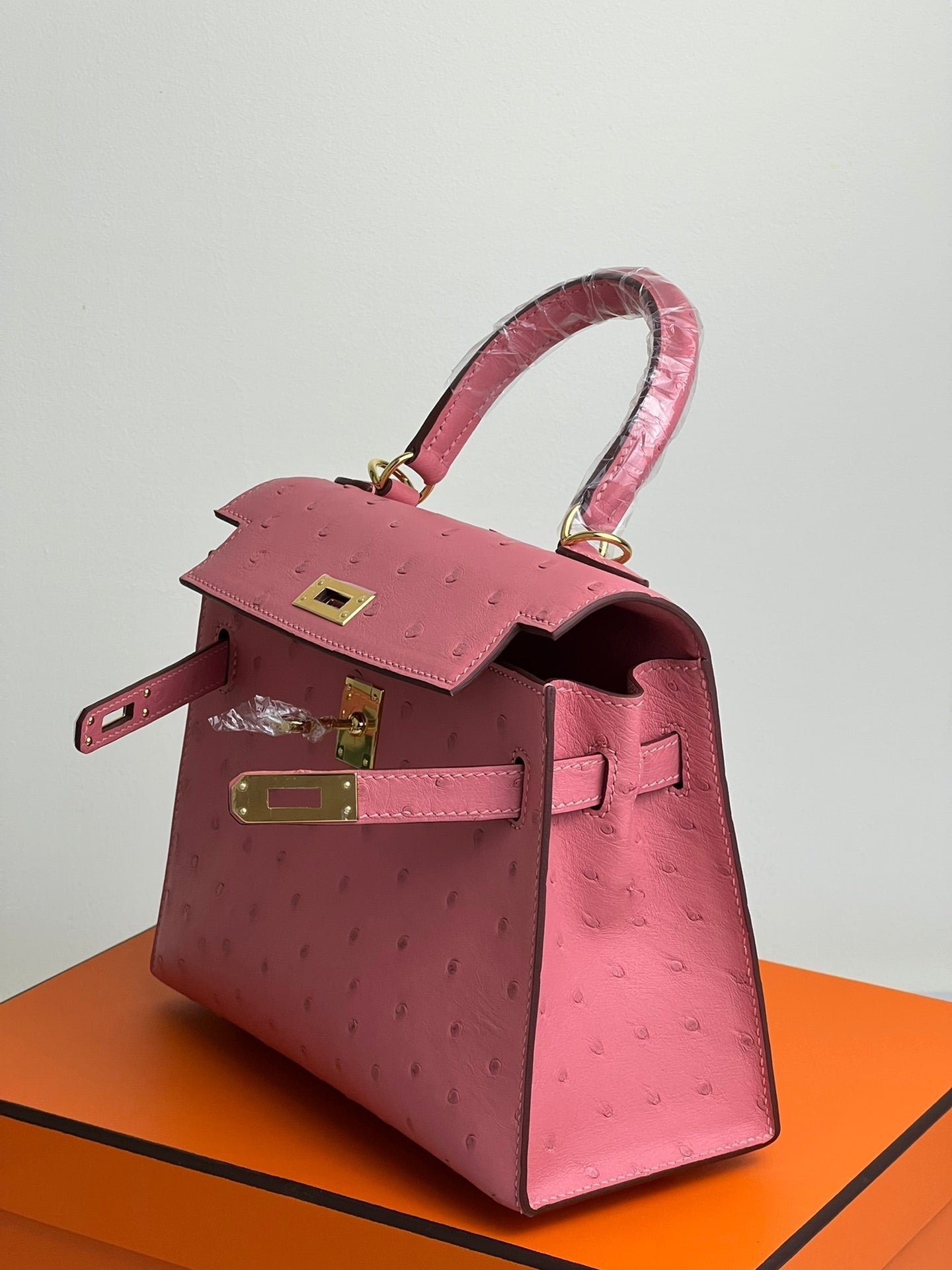 SAC KELLY 20 EN CUIR D'AUTRUCHE ROUGE ROSE AVEC QUINCAILLERIE DORÉ (FABRIQUÉ SUR COMMANDE)