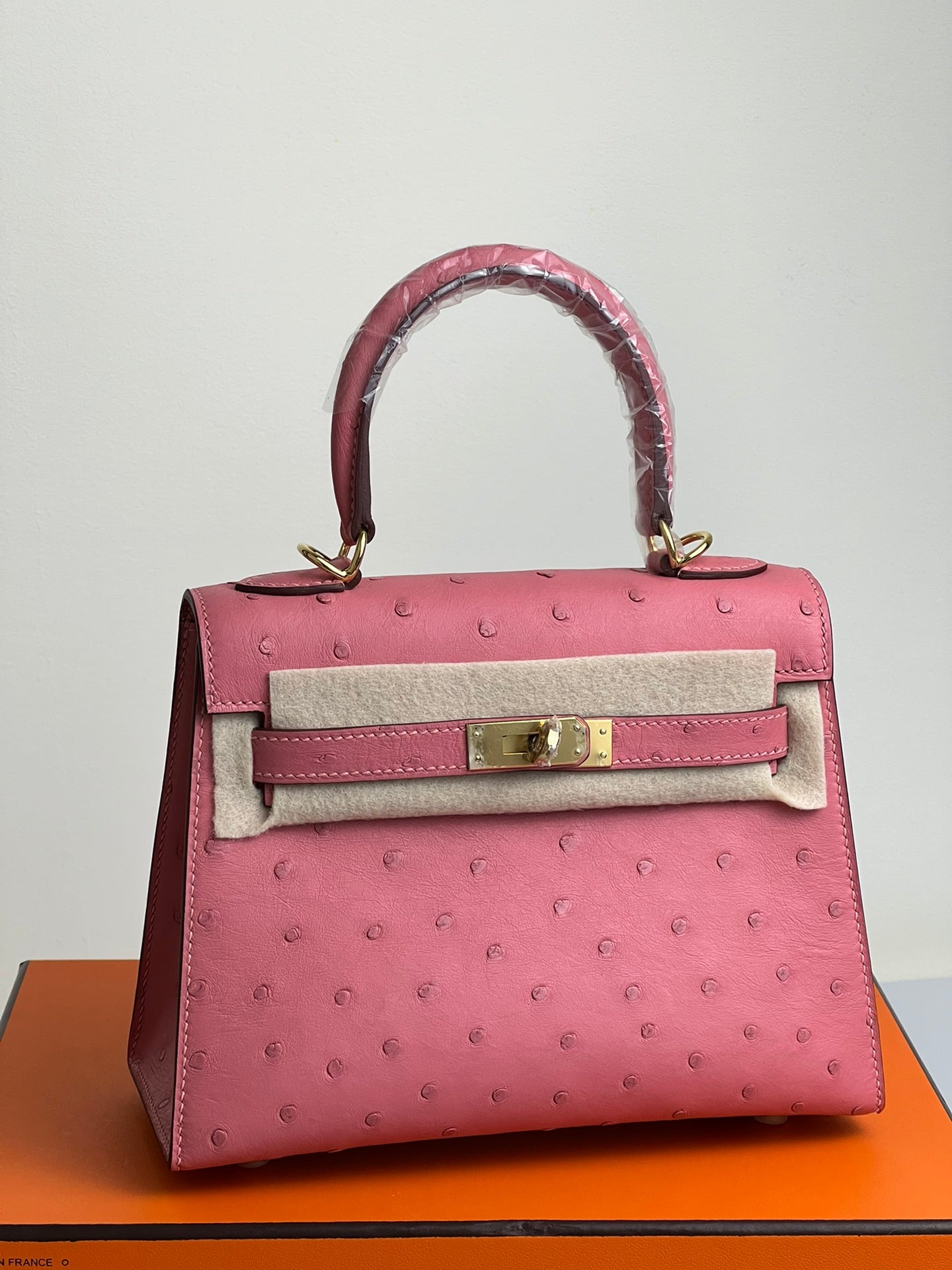 SAC KELLY 20 EN CUIR D'AUTRUCHE ROUGE ROSE AVEC QUINCAILLERIE DORÉ (FABRIQUÉ SUR COMMANDE)