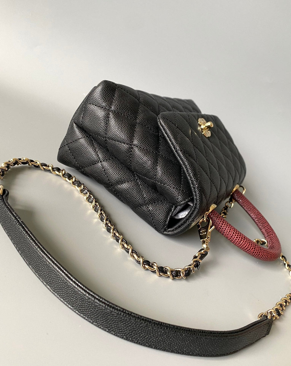 SAC À RABAT AVEC POIGNÉE EN COCO 23 CM CAVIAR MATELASSÉ NOIR AVEC POIGNÉE SUPÉRIEURE ROUGE FONCÉ