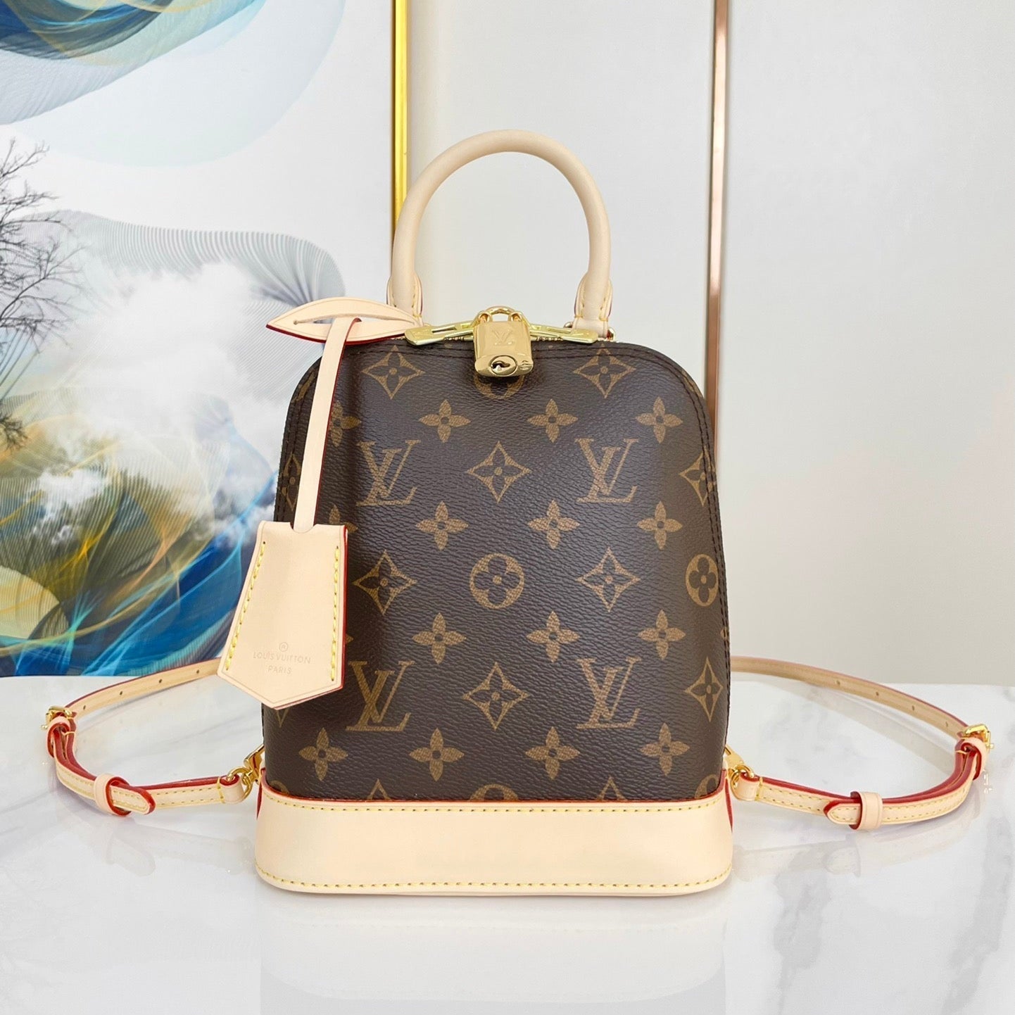 SAC À DOS ALMA 20 EN TOILE MONOGRAMME MARRON ET GARNITURE EN CUIR DE VEAU BEIGE BOUCLE DORÉE