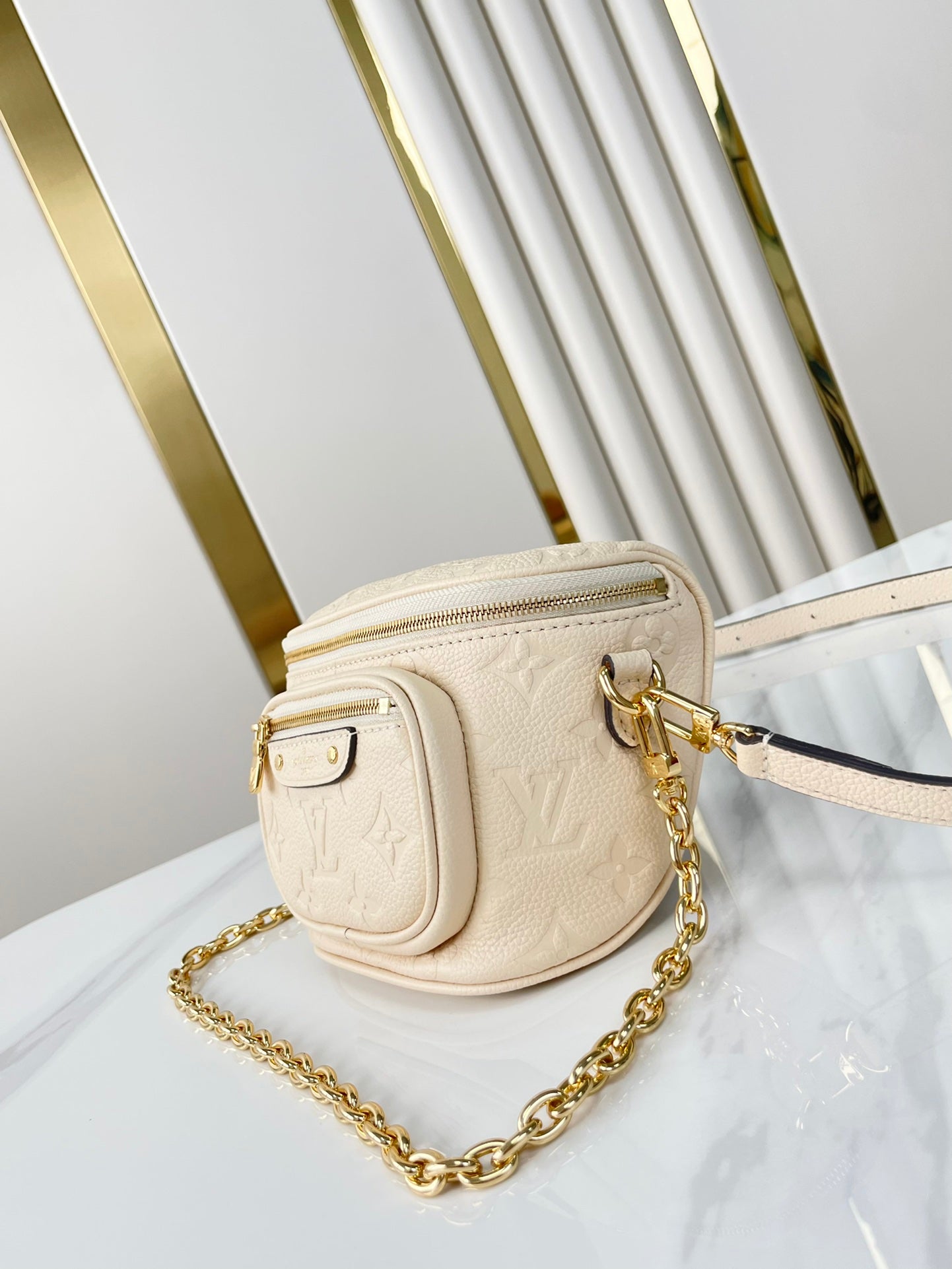MINI SAC BANANE 17 EN CUIR EMPREINTE MONOGRAMME CRÈME, QUINCAILLERIE DORÉ
