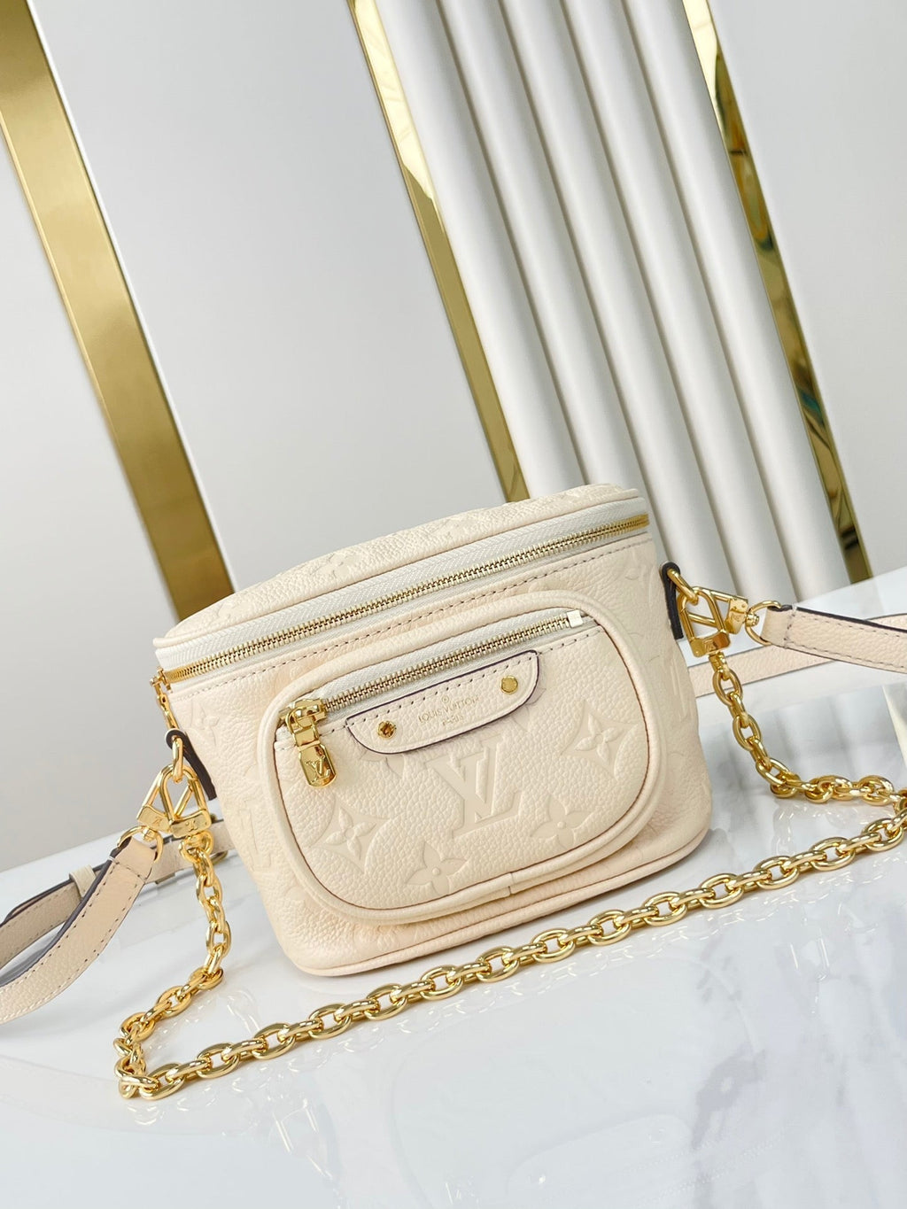 MINI SAC BANANE 17 EN CUIR EMPREINTE MONOGRAMME CRÈME, QUINCAILLERIE DORÉ