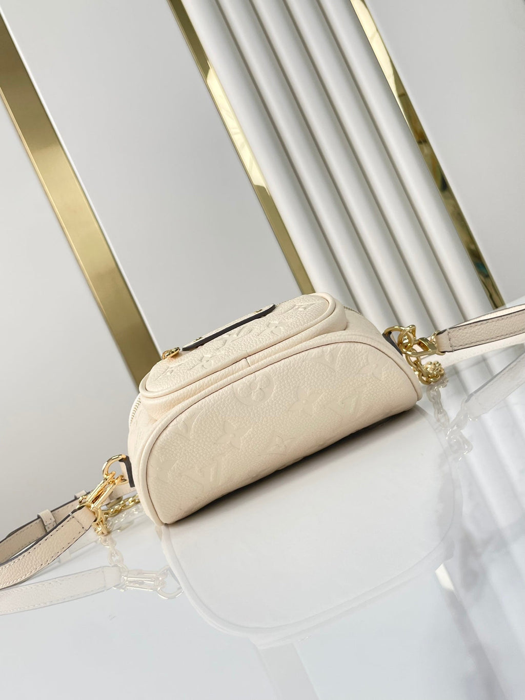 MINI SAC BANANE 17 EN CUIR EMPREINTE MONOGRAMME CRÈME, QUINCAILLERIE DORÉ