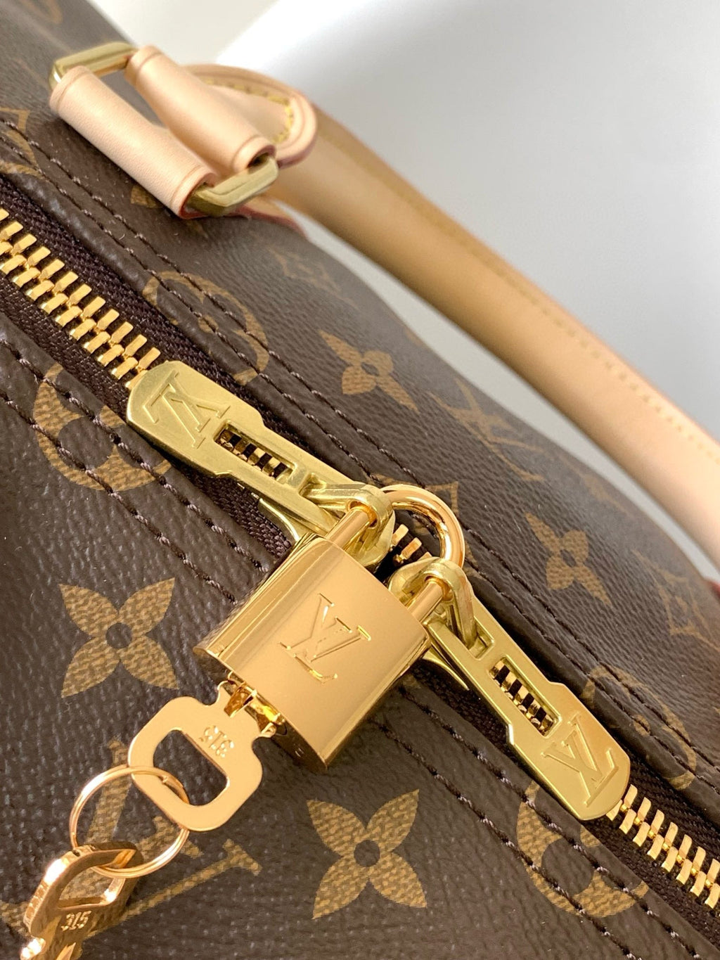 Sac bandoulière Louis Vuitton Keepall 55 en toile monogrammée marron et métal doré