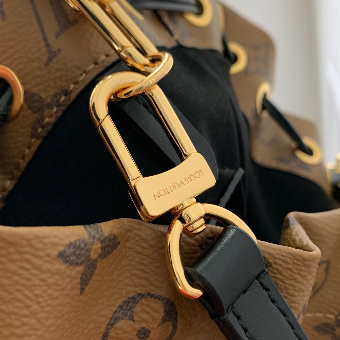 Malle Noé 23 en toile inversée monogrammée marron et quincaillerie dorée