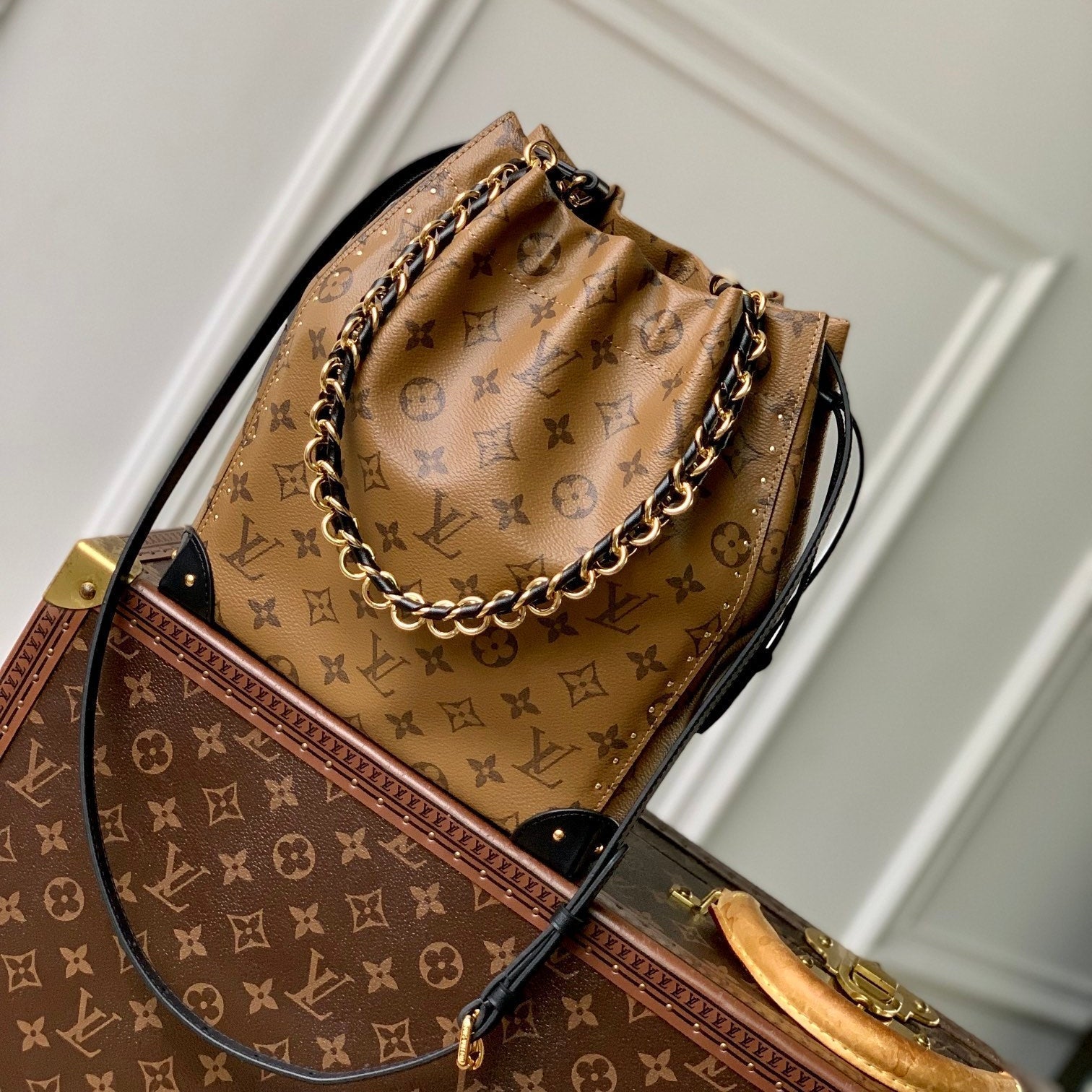 Malle Noé 23 en toile inversée monogrammée marron et quincaillerie dorée