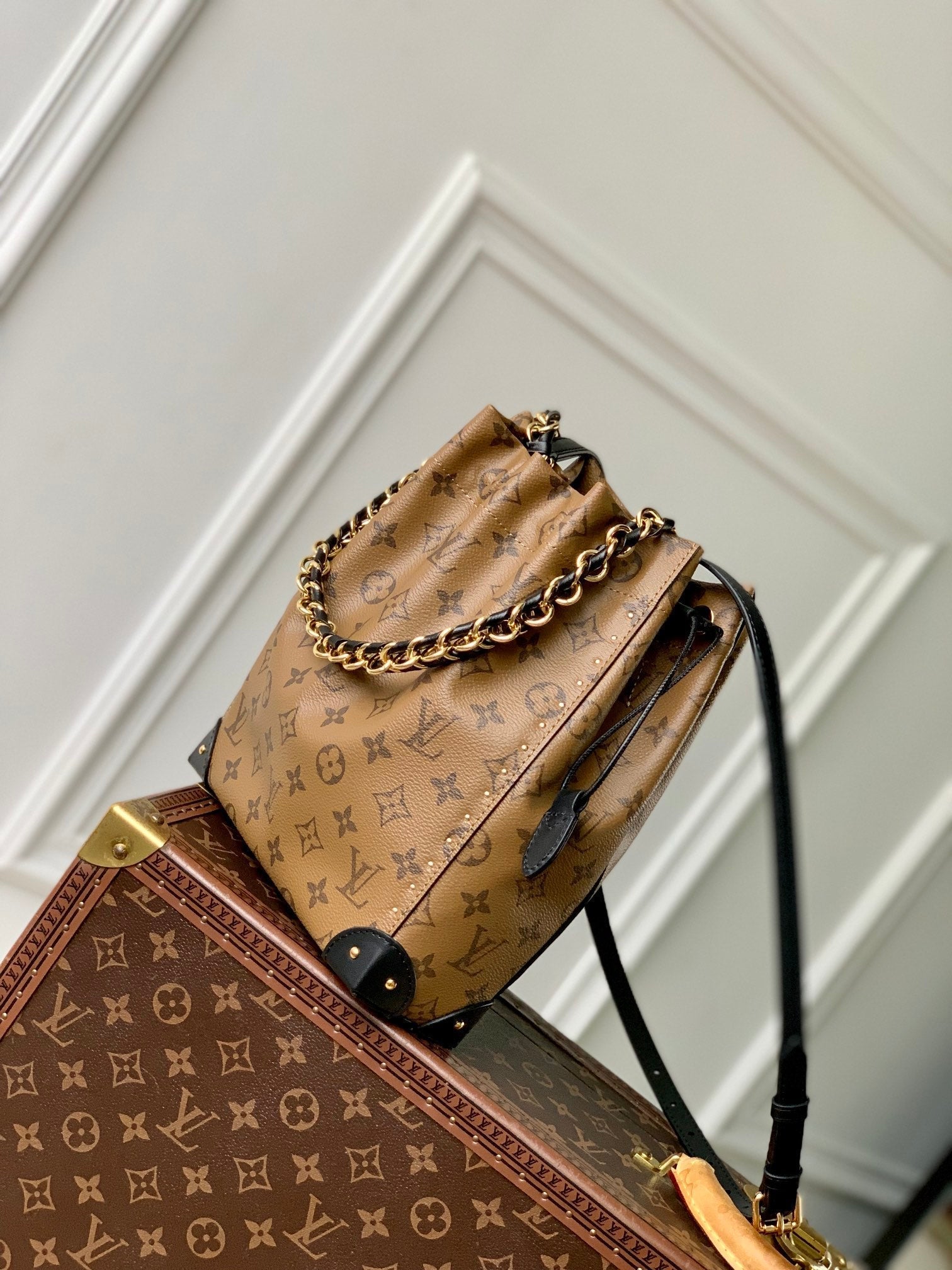Malle Noé 23 en toile inversée monogrammée marron et quincaillerie dorée