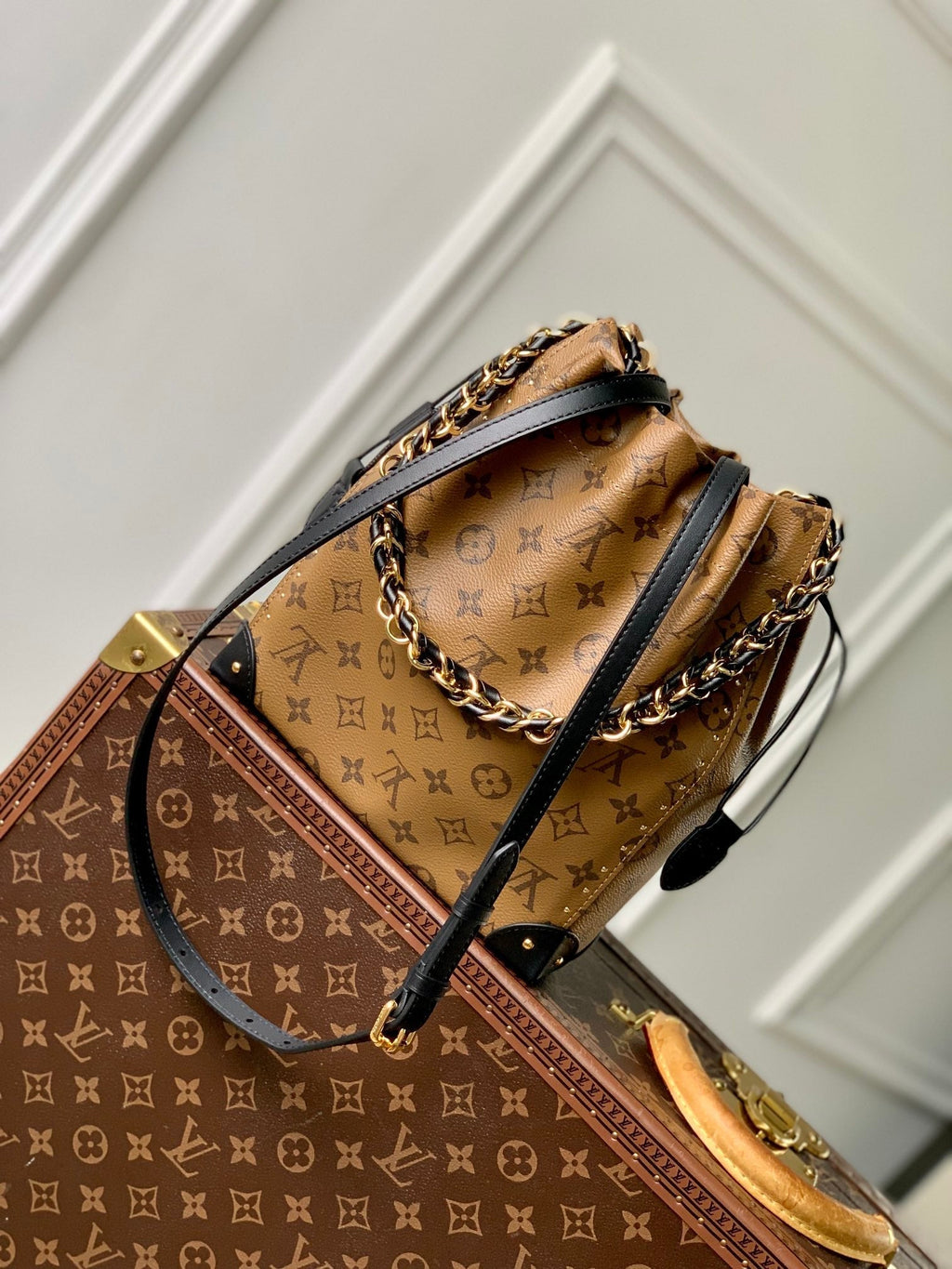 Malle Noé 23 en toile inversée monogrammée marron et quincaillerie dorée
