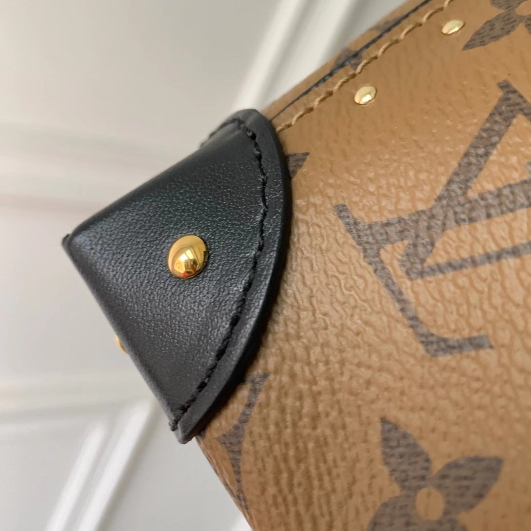 Malle Noé 23 en toile inversée monogrammée marron et quincaillerie dorée