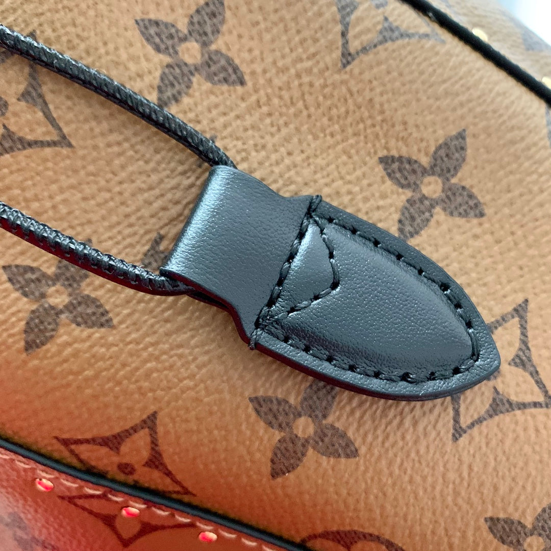 Malle Noé 23 en toile inversée monogrammée marron et quincaillerie dorée