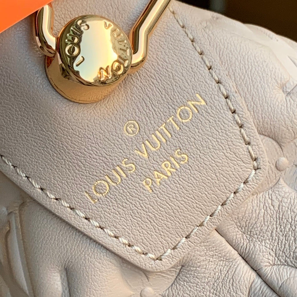 COUSSIN MM 38 EN CUIR DE VEAU BEIGE AVEC MONOGRAMME EN MÉTAL ESTAMPÉ, ACIER DORÉ