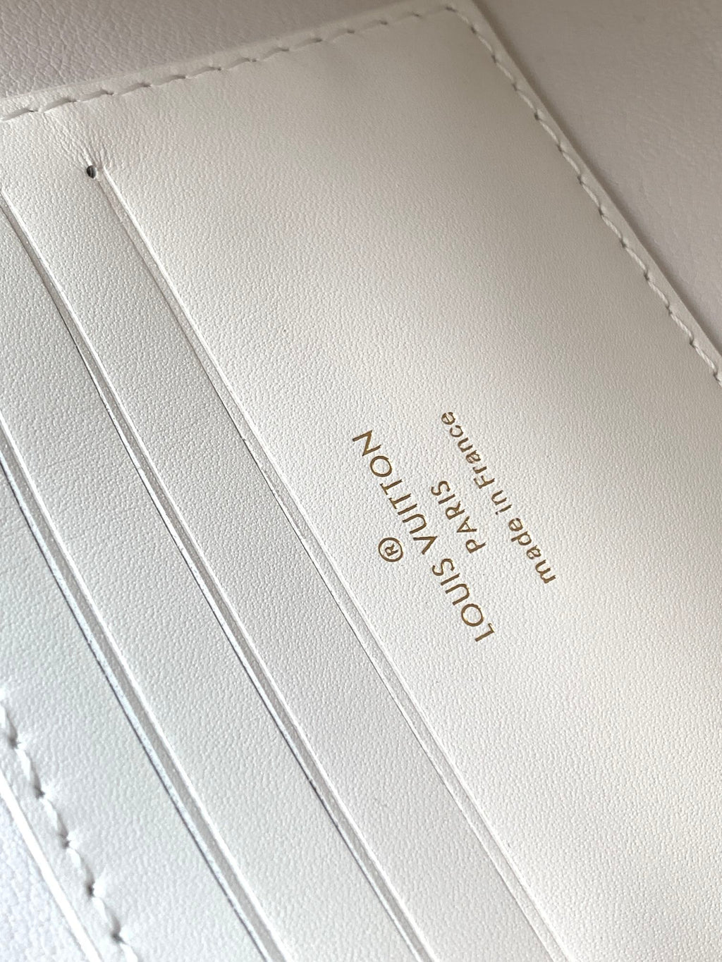 PORTEFEUILLE SUR CHAÎNE CAPUCINES 23 EN CUIR DE VEAU LISSE BLANC, QUINCAILLERIE DORÉE