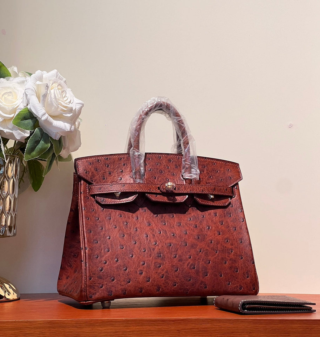 SAC KELLY SELLIER 25 EN CUIR D'AUTRUCHE ROUGE BAIE AVEC QUINCAILLERIE DORÉ (FABRIQUÉ SUR COMMANDE)