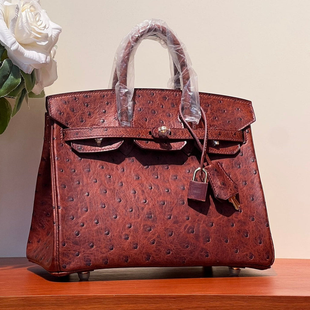 SAC KELLY SELLIER 25 EN CUIR D'AUTRUCHE ROUGE BAIE AVEC QUINCAILLERIE DORÉ (FABRIQUÉ SUR COMMANDE)